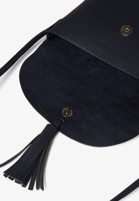 Borsa a tracolla in pelle blu navy con esterno texture, interno liscio, chiusura magnetica e dettaglio con nappina. L'interno è spazioso e non foderato.
