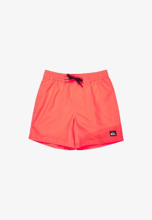 Shorts de bain corail vif avec taille élastique, cordon noir, et un petit patch logo noir et blanc sur la jambe gauche.