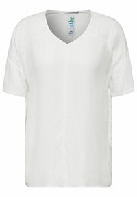 Vit V-ringad blus med korta ärmar, tillverkad av ett mjukt tyg. Har sidofästen och en avslappnad passform. Diskret lyster lägger till textur.