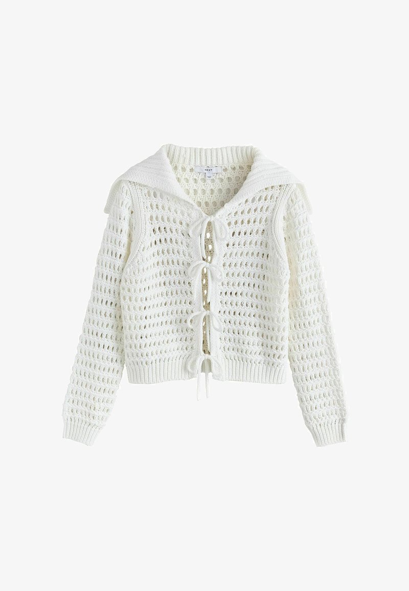 Cardigan en tricot blanc avec un motif à maille ouverte, un col style marin et des nœuds noués à l’avant comme fermetures.