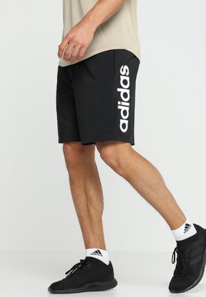 Schwarze Sportshorts aus atmungsaktivem Stoff, mit großem weißen adidas-Logo an der Seite und einem bequemen, lockeren Schnitt.