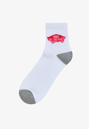 Calcetín de algodón blanco con un logo rojo "VANS OFF THE WALL" en un parche en forma de pez, con acentos en gris en la puntera y el talón.