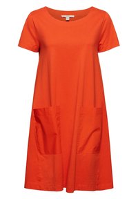 Orange bomullsklänning med korta ärmar, rund halsringning och två stora frontfickor. Lätt passform med knälång nederkant. Slät textur.