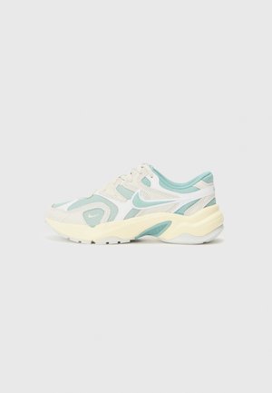 Light blue and cream athletic shoe featuring mesh and suede materials, a chunky sole, and a distinctive wavy design with a white swoosh.
