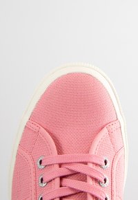 Rosa kanvas sneakers med en strukturerad yta, vit gummikappa, matchande snören och silverfärgade öglor. Rund, lågtoppad design.