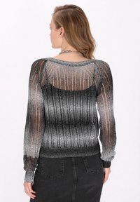 Pulover tricotat ombre negru și argintiu, cu textură transparentă, mâneci lungi și manșete cu șnur, având un design cu spatele decupat.