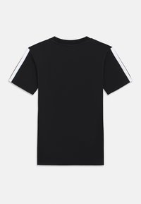 Μαύρο μπλουζάκι με κοντό μανίκι, με λευκές ρίγες στους ώμους. Φτιαγμένο από μαλακό ύφασμα με στρογγυλή λαιμόκοψη και ίσια γραμμή.