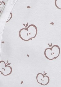 White fabric with a repeated apple pattern in muted brown, featuring small details like seeds and leaves. Button closure on one side.