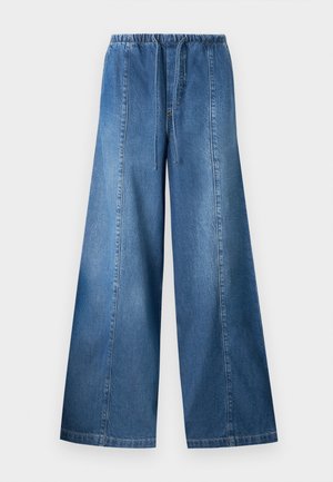 Laiade sinise teksapüksid elastse vöörihma ja paelaga, millel on iga jala peal vertikaalsed õmblused.