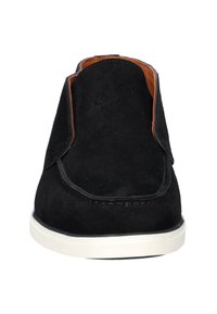 Zwarte suède instap schoen met een ronde neus, contrasterende tan accenten en een witte rubberen zool met zichtbare stiksels.