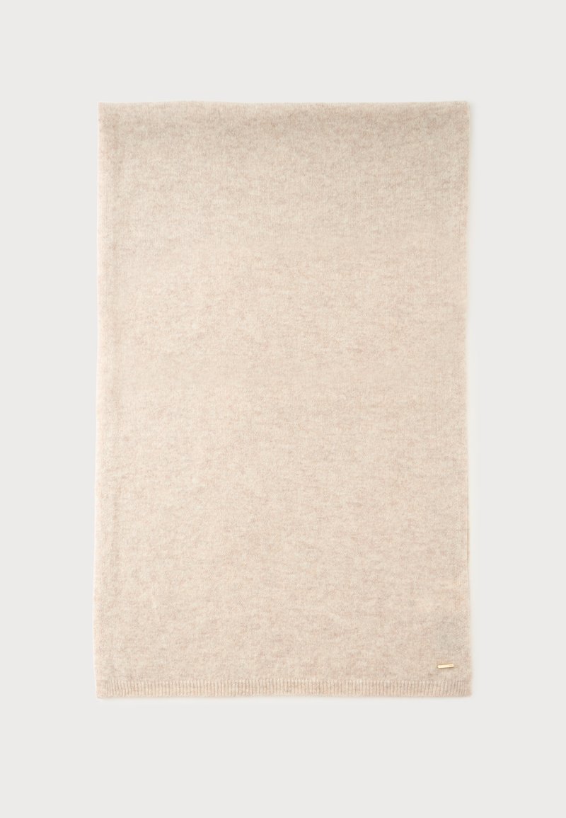Bufanda rectangular de lana beige suave con bordes sutilmente acanalados y una pequeña etiqueta de marca dorada en la esquina inferior sobre un fondo blanco.
