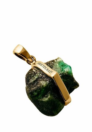 Colgante de piedra preciosa verde sin pulir asegurado con un cierre de oro grabado con "ARISTOCRAZY" sobre un fondo blanco.