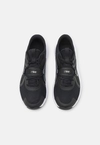 Scarpe atletiche nere con tomaia in rete e sintetico, dotate di lacci tondi, colletto imbottito e suola in gomma bianca. Logo Nike sulla linguetta.