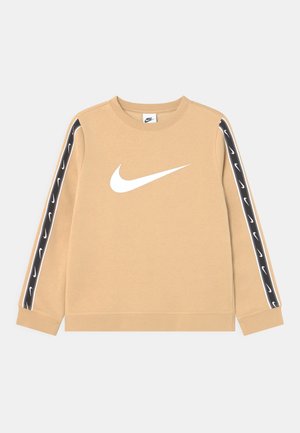 Beige sweatshirt med lange ærmer, prydet med et hvidt Nike-logo foran og sorte detaljer med mini-logoer langs ærmerne.