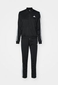 Czarny dres z pełnym zamkiem, z białymi paskami na rękawach i nogawkach, z małymi białymi logotypami Adidas na piersi i górnej części uda.