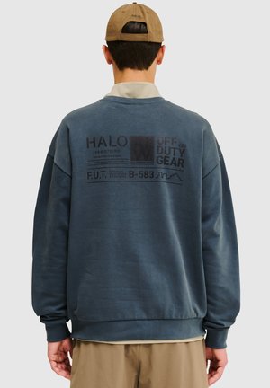 Marineblauwe sweatshirt met een losse pasvorm, voorzien van tekst in grafische stijl op de achterkant en een geribbelde zoom. Gemaakt van zachte stof, met lange mouwen en een ronde hals.