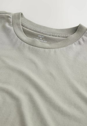 Camiseta de color gris claro con cuello redondo y corte regular. Fabricada con tejido suave, presenta una textura mínima y un diseño sencillo.