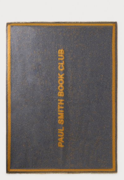 Правоъгълен тъмен сив килим с тънка оранжева рамка и думите "PAUL SMITH BOOK CLUB" в оранжево, центрирани вертикално.