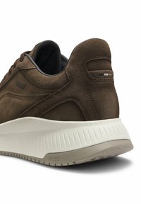 Basket en daim marron avec semelle texturée couleur écrue, talon arrondi, doublure intérieure noire et "BOSS" embossé sur le côté et la semelle.