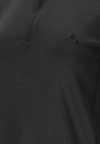 Zwarte pullover met rits en hoge hals, gemaakt van textuurstof. Heeft een klein zwart logo en subtiele stikseldetails. Zacht en lichtgewicht materiaal.