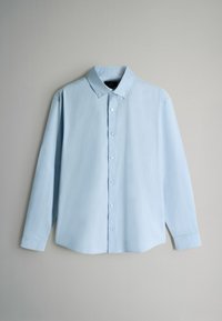 Gaiši zils garām piedurknēm krekls, izgatavots no gludas auduma, ar pogājamu apkakli, pilnīgu pogu aizdari priekšpusē un izliekta apakšmalu.