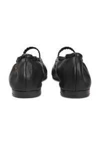 Μαύρα δερμάτινα παπούτσια φλατ με πτυχώσεις στο πίσω μέρος και πλεκτή ελαστική λεπτομέρεια. Λείες υφές, χαμηλό τακούνι και στρογγυλεμένο σχήμα μύτης.