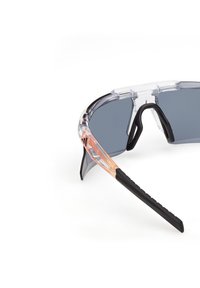 Okulary sportowe z przezroczystą oprawką, szarymi przyciemnianymi soczewkami i czarnymi gumowymi akcentami; charakteryzujące się unikalnym designem z teksturowanymi końcówkami zauszników.