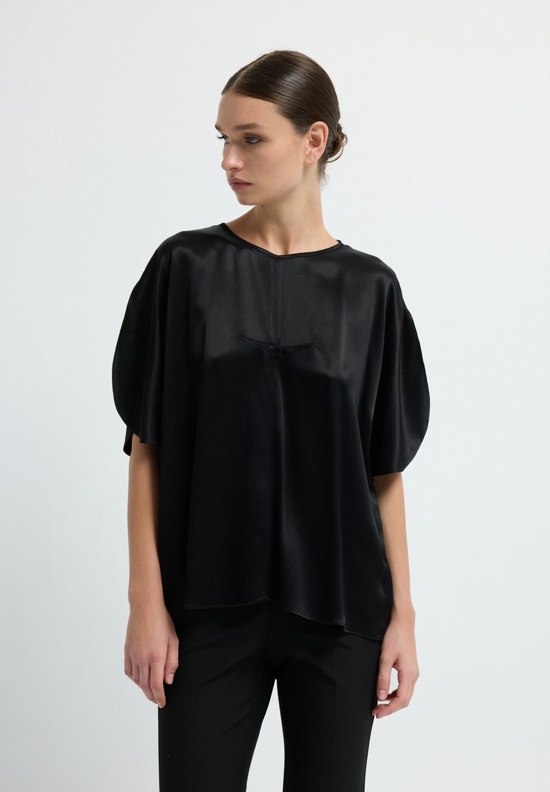 Top in satin nero con una vestibilità rilassata, scollo rotondo e maniche corte, caratterizzato da una texture liscia e da dettagli drappeggiati sottili.