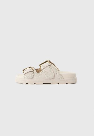 Sandali beige chiaro con due cinturini regolabili, materiale superiore testurizzato e suola piatta con scanalature visibili per una migliore trazione.