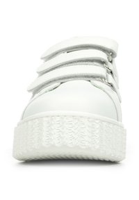 Sneaker bianco con tre strisce adesive regolabili, suola in gomma texturizzata, parte superiore in materiale sintetico liscio e design della punta arrotondata.