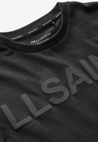 Mustvalge puuvillane T-särk, millel on tekstuuriga, ülisuur "ALLSAINTS" logo ees. Ümar kaelus ja pehme kangas. Valmistatud Türgis.