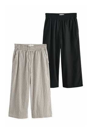 Dve dvojice širokých nohavíc s elastickým pásom a skrátenou dĺžkou: jedny v čiernej farbe, druhé čierno-biele kárované s bočnými vreckami.