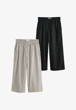 Dwie pary szerokich, luźnych spodni o kroju 7/8 z elastycznym paskiem w talii: jedna w kolorze czarnym, druga w czarno-białą kratę z bocznymi kieszeniami.