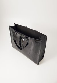Sac cabas noir brillant avec motif crocodile et deux anses, présenté vide sur un fond uni.