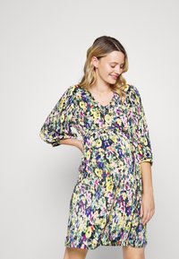 Vestido de maternidade floral com mangas três quartos, decote em V, estampado colorido e cintura elástica, oferecendo um ajuste confortável.
