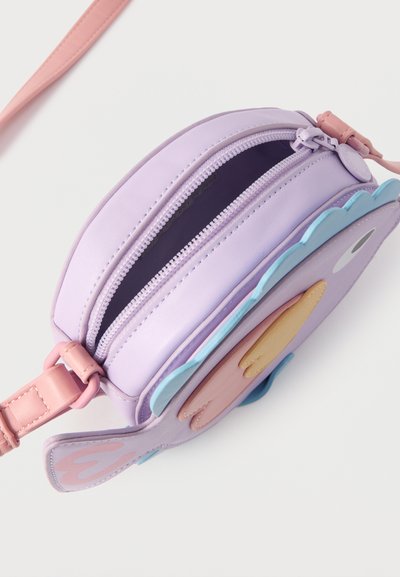 Μικρή μοβ τσάντα χιαστί με ροζ λουρί, σχέδιο φτερού πουλιού σε μπλε και μπεζ, με μερικώς ανοιχτό φερμουάρ σε λευκό φόντο.