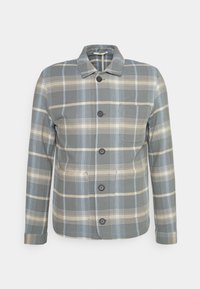 Camisa abotoada em material de flanela suave, com um padrão de xadrez azul e bege, gola clássica e três botões na parte frontal.