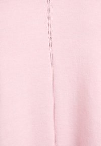 Svetloružová pletená látka s centrálnym švom a jemnými švíkovými detailmi. Mäkká textúra vhodná na bežné nosenie.