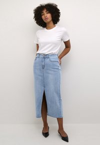Gonna di jeans azzurro chiaro con spacco frontale, design a vita alta e classico stile a cinque tasche. Abbinata a una t-shirt bianca semplice.