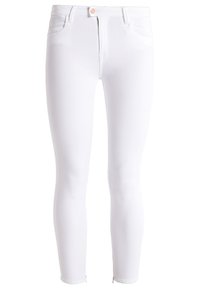 Jeans skinnies de denim blanco con un diseño ajustado, bolsillos delanteros y cremallera. Presenta un pequeño detalle de logo en la cintura.