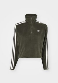 Olivgrön fleece-pullover med hög krage och halvdragkedja. Har vita lodräta ränder längs ärmarna och en logotyp på bröstet.