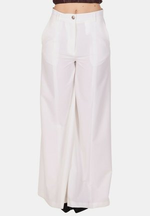 Pantaloni bianchi a vita alta e gamba larga con bottone frontale e tasche, indossati da una persona con la pancia visibile.