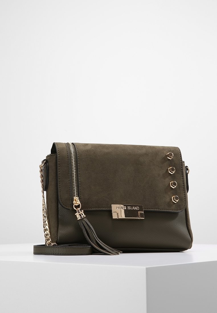 Dunkelgrüne Handtasche aus Wildleder und Kunstleder, mit Klappe und Metallakzenten, einem Reißverschluss und einer dekorativen Quaste.