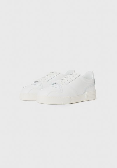 White sneakers made of smooth leather with a flat sole, featuring a subtle blue accent and classic lace-up design. No visible patterns.
