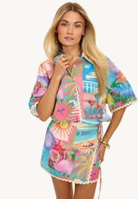 Robe mini enroulée colorée et chemise assortie présentant des motifs tropicaux, des bords festonnés, des manches courtes et un détail de taille à nouer.