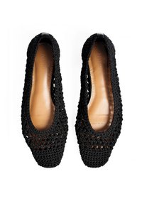 Ballerines noires en crochet avec un design texturé, bout arrondi et semelle intérieure en cuir lisse de couleur tan. Présentent des ouvertures sur toute la matière supérieure.