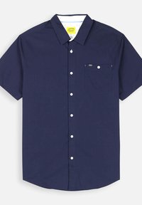 Chemise à manches courtes de couleur navy avec une poche poitrine, boutons blancs et tissu lisse. Étiquette visible au col.