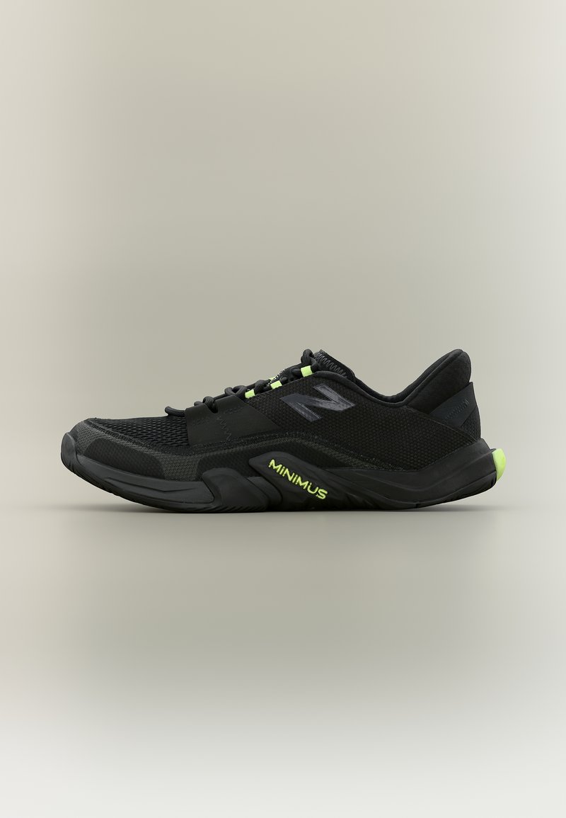 Μαύρο αθλητικό παπούτσι με πλέγμα επάνω μέρος, νεον πράσινες λεπτομέρειες και την επιγραφή «MINIMUS» στη χοντρή σόλα σε πλαϊνή όψη σε ουδέτερο φόντο.