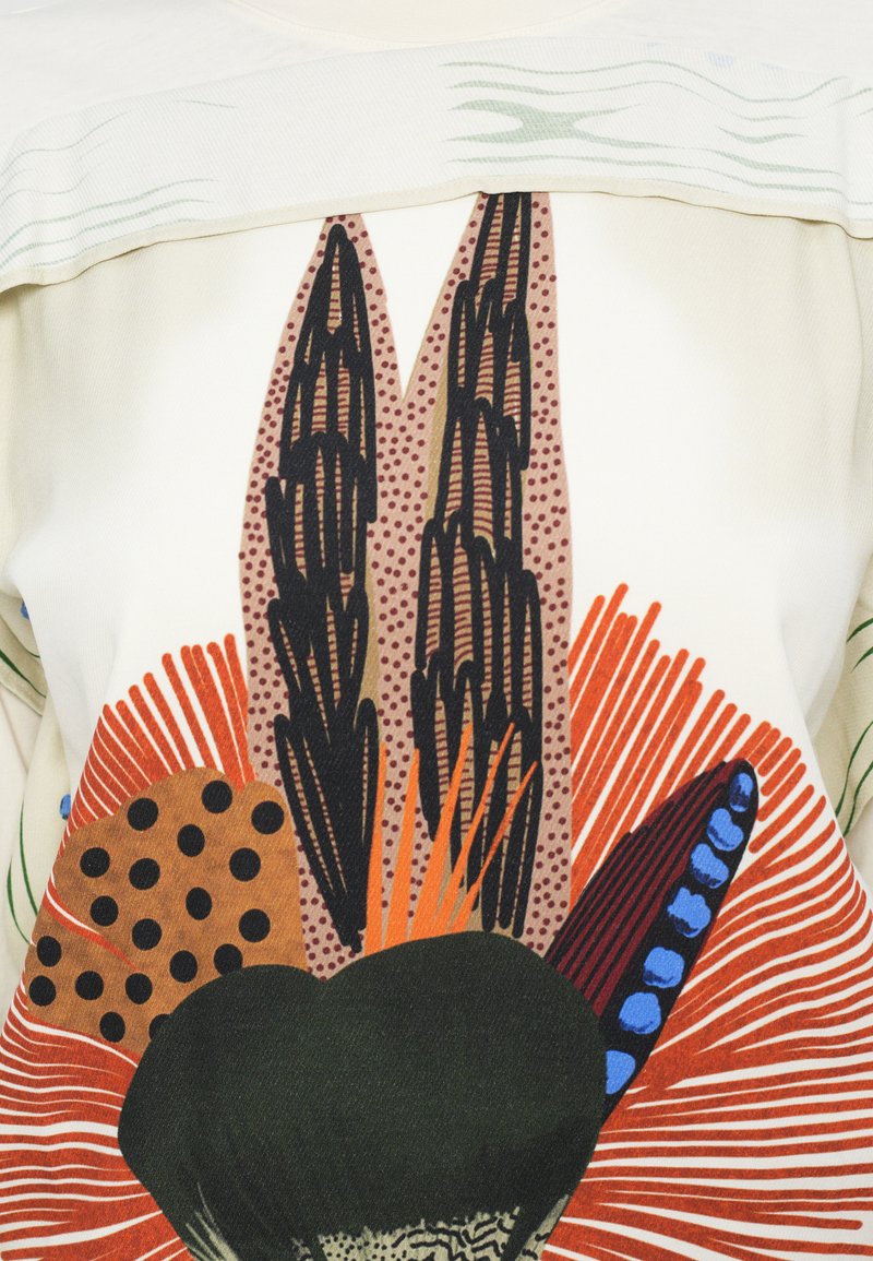 Motivo floreale astratto colorato con forme nere, arancioni, marroni e blu su uno sfondo di tessuto bianco.