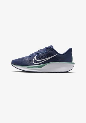 Zapatilla de running Nike en malla azul marino oscuro con el swoosh blanco, detalles en verde, suela acolchada y suela exterior texturizada para mayor agarre.